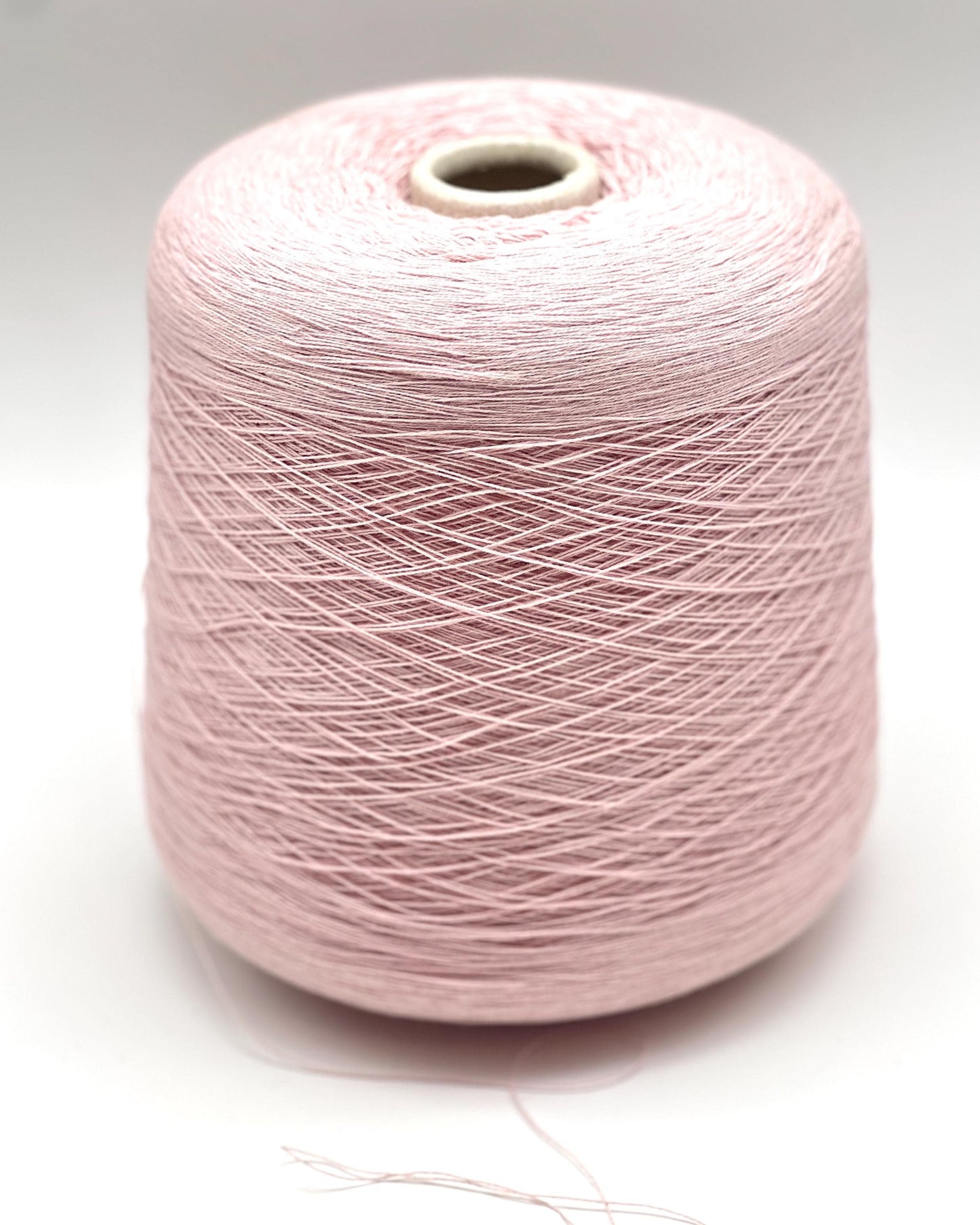 Pink spool of yarn on a white background