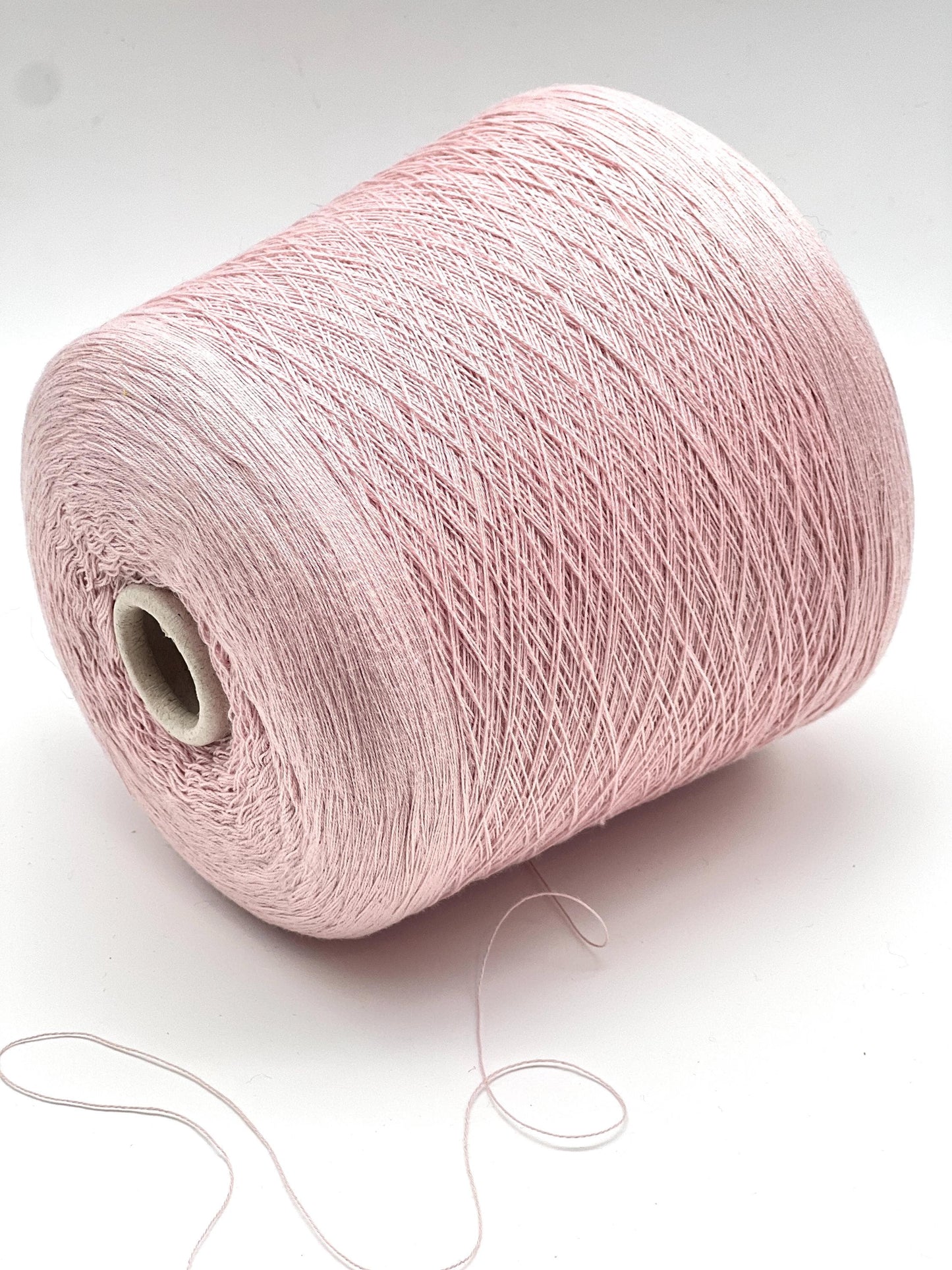 Pink yarn spool on a white background