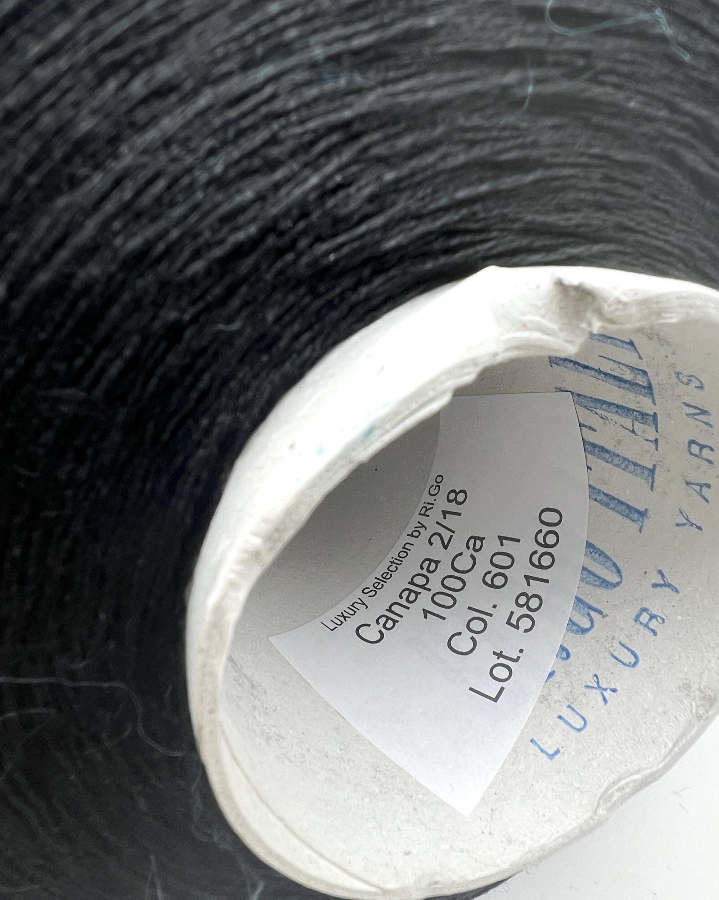 Spool of yarn with a label on a dark textured background