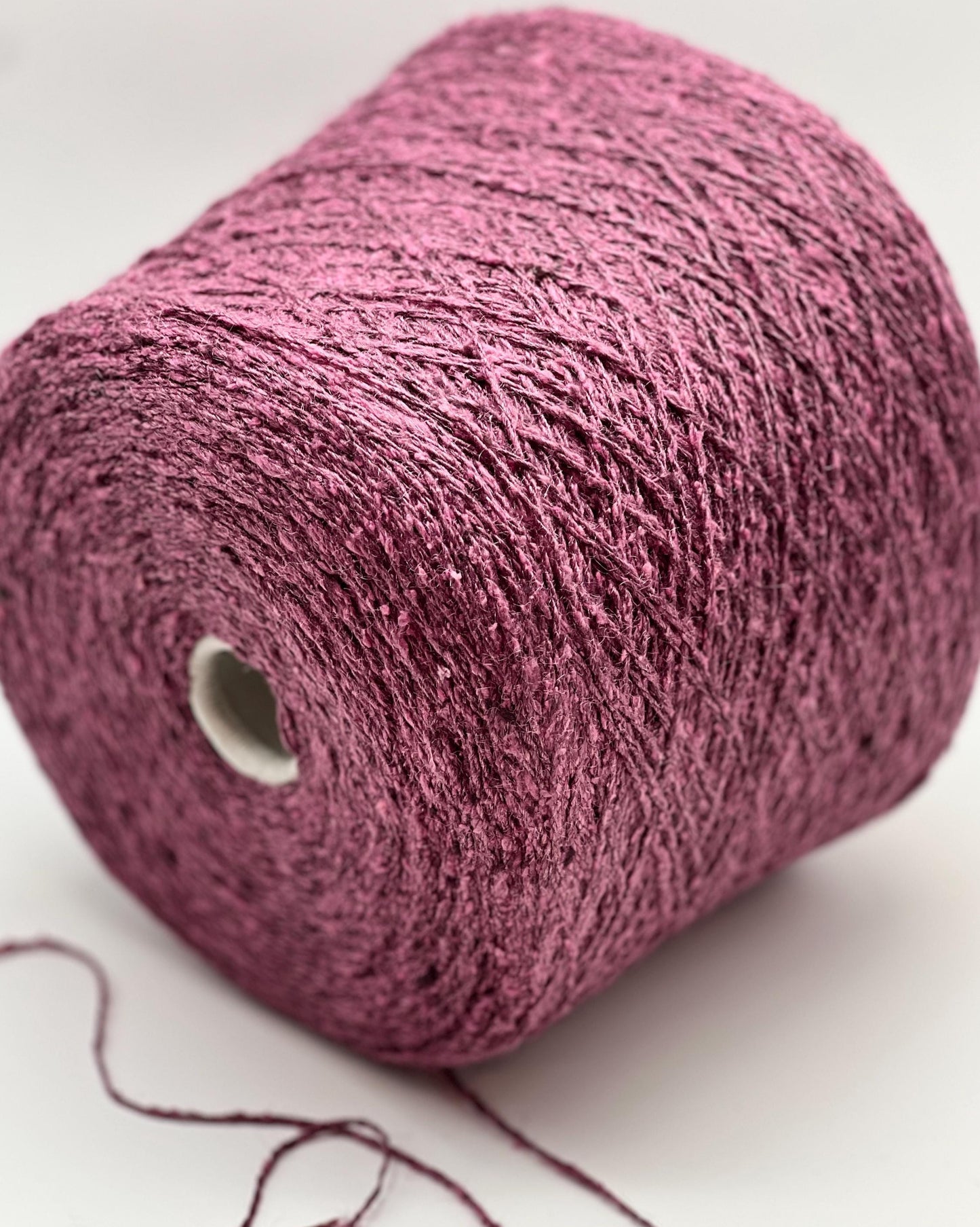 Close-up of a pink skein of yarn on a white background