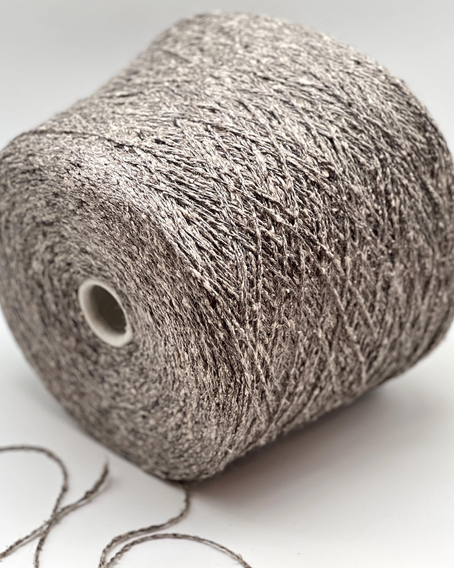 Spool of gray yarn on a white background
