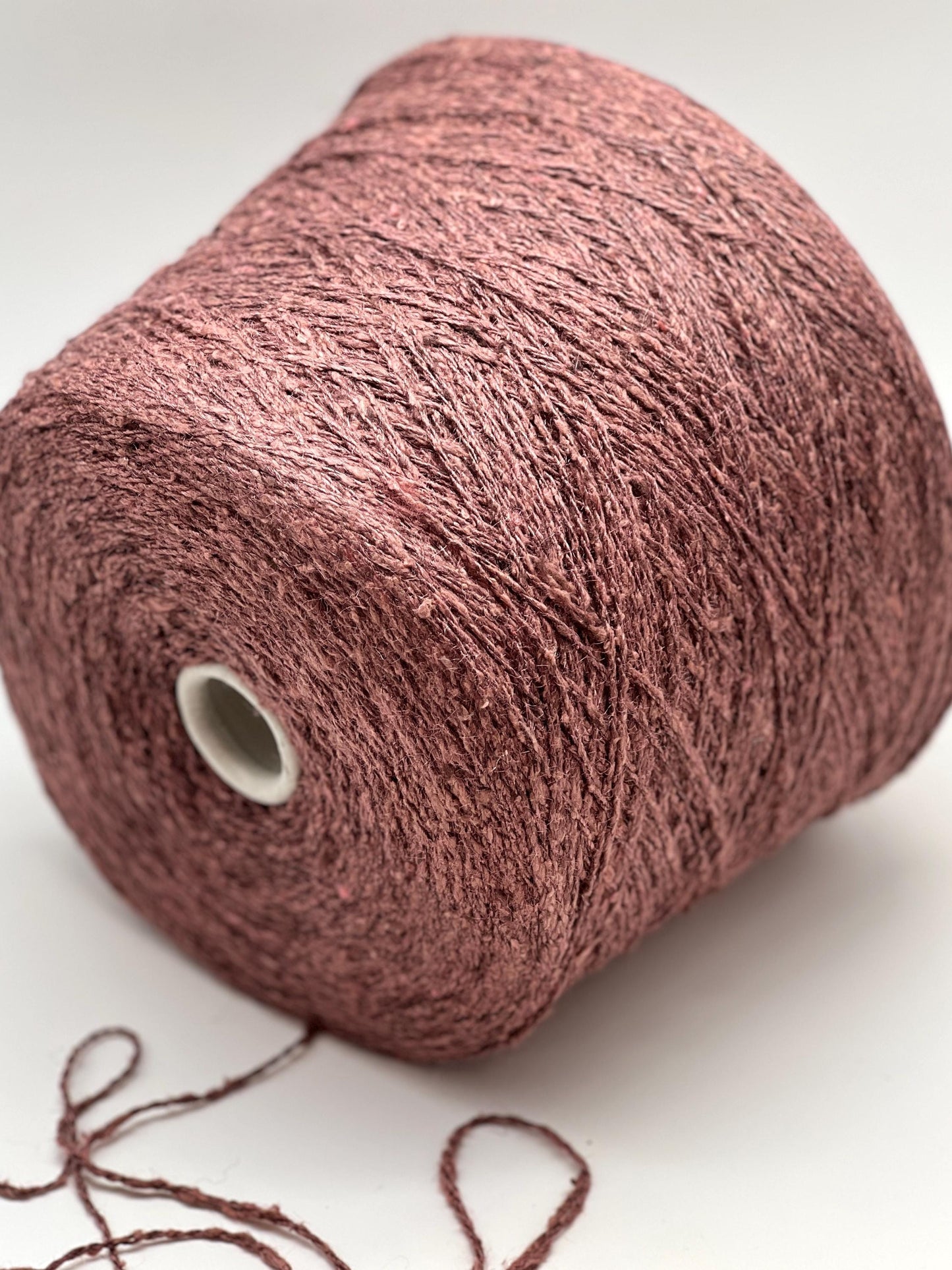 Spool of pink yarn on a white background