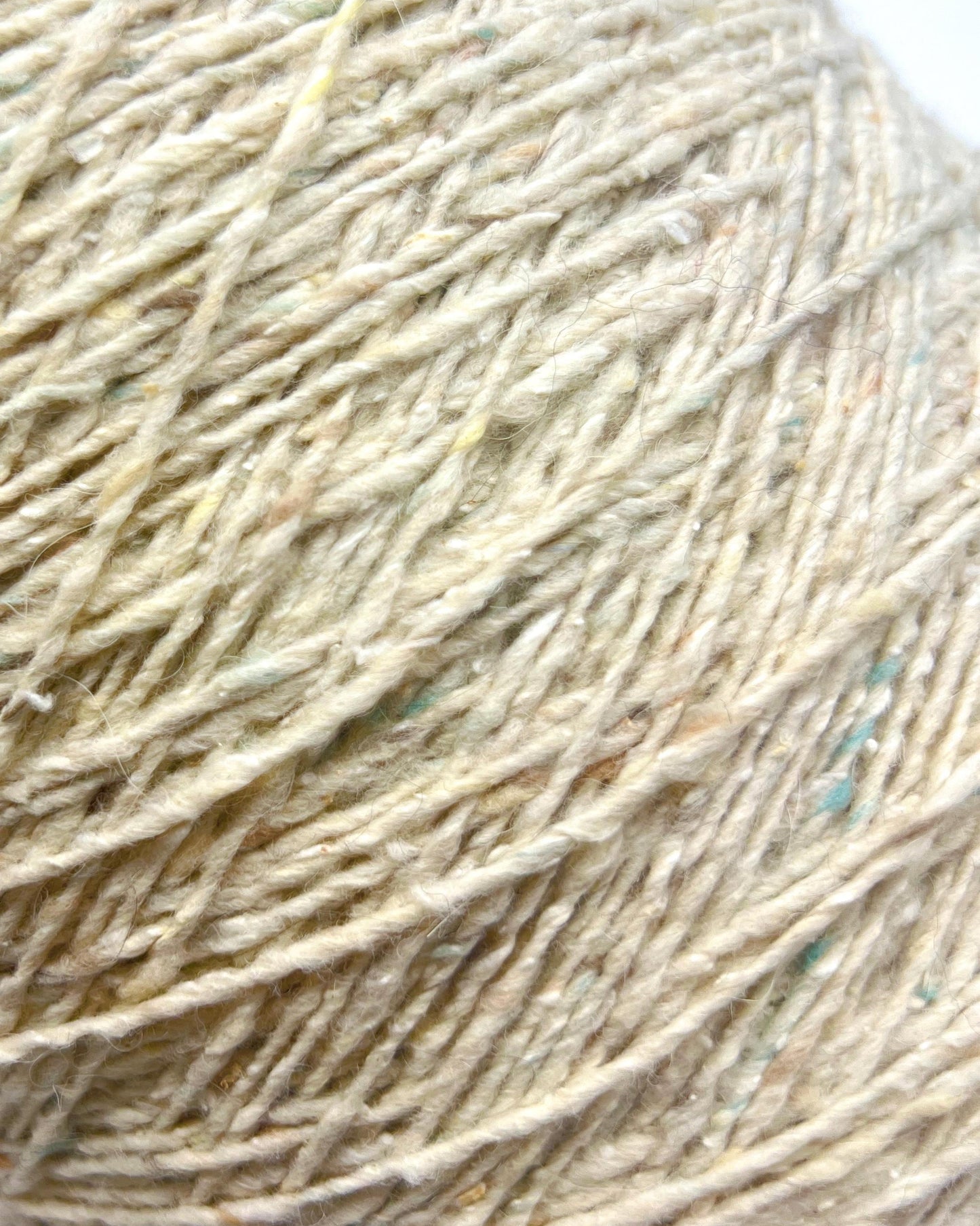 Close-up of beige yarn with specks of other colors