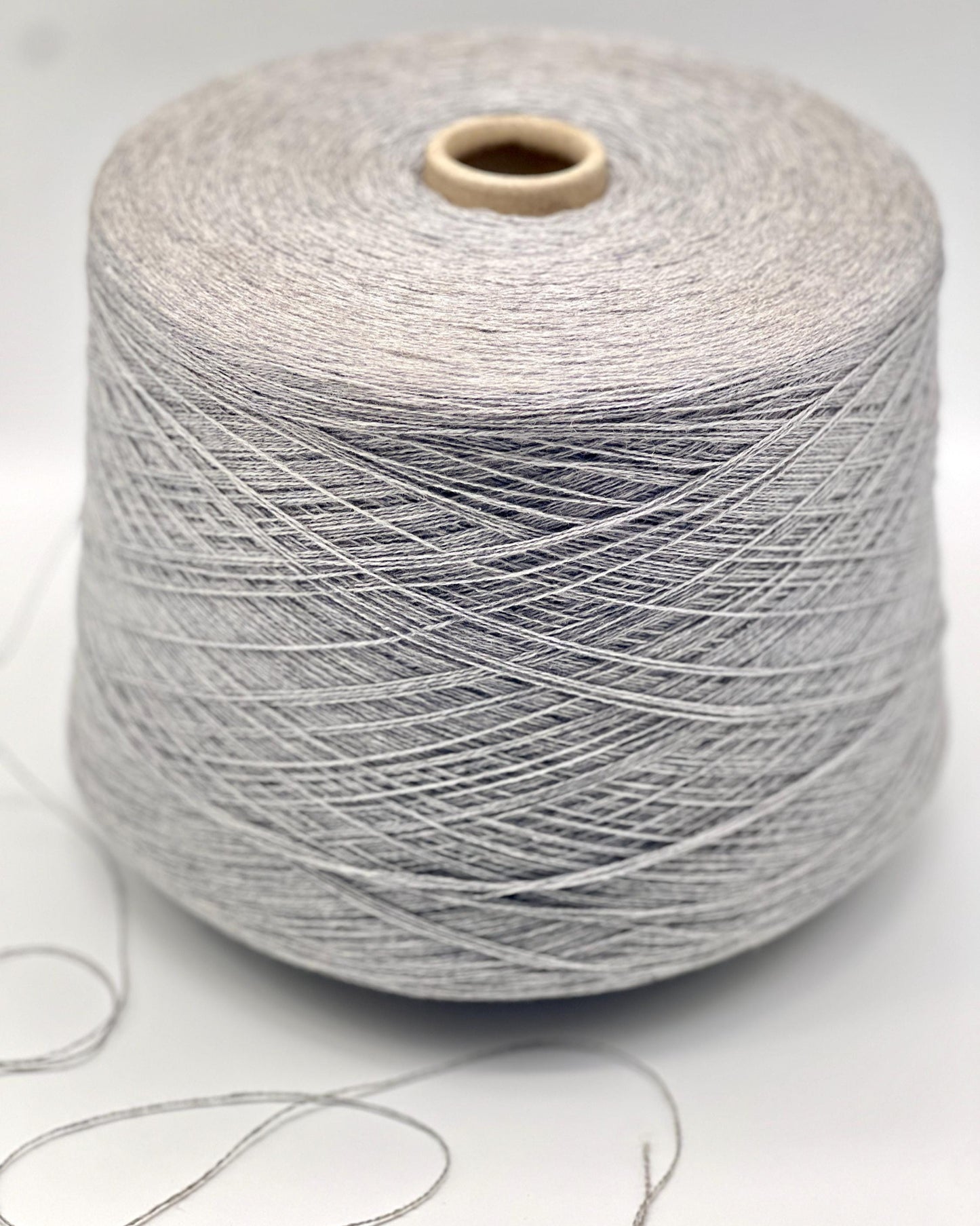 Spool of gray yarn on a white background