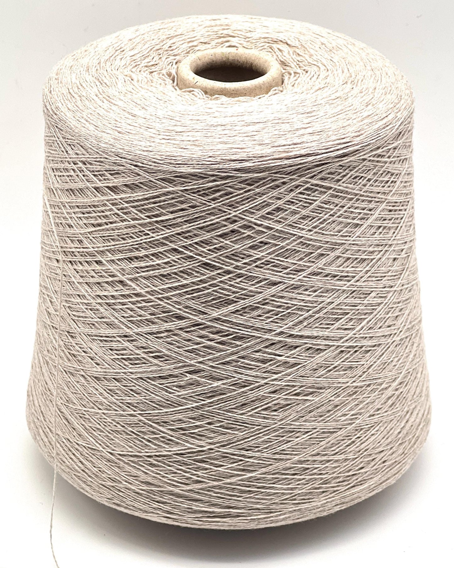 Spool of beige thread on a white background
