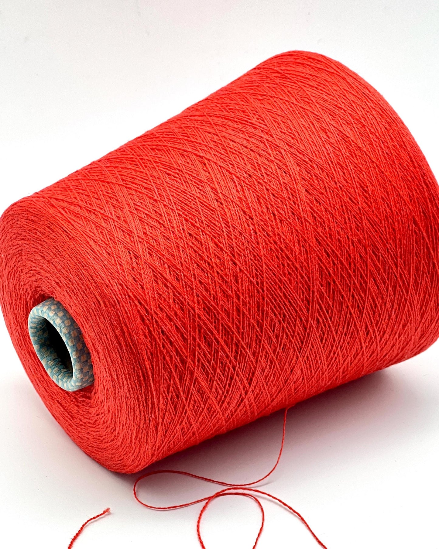 Red spool of yarn on a white background