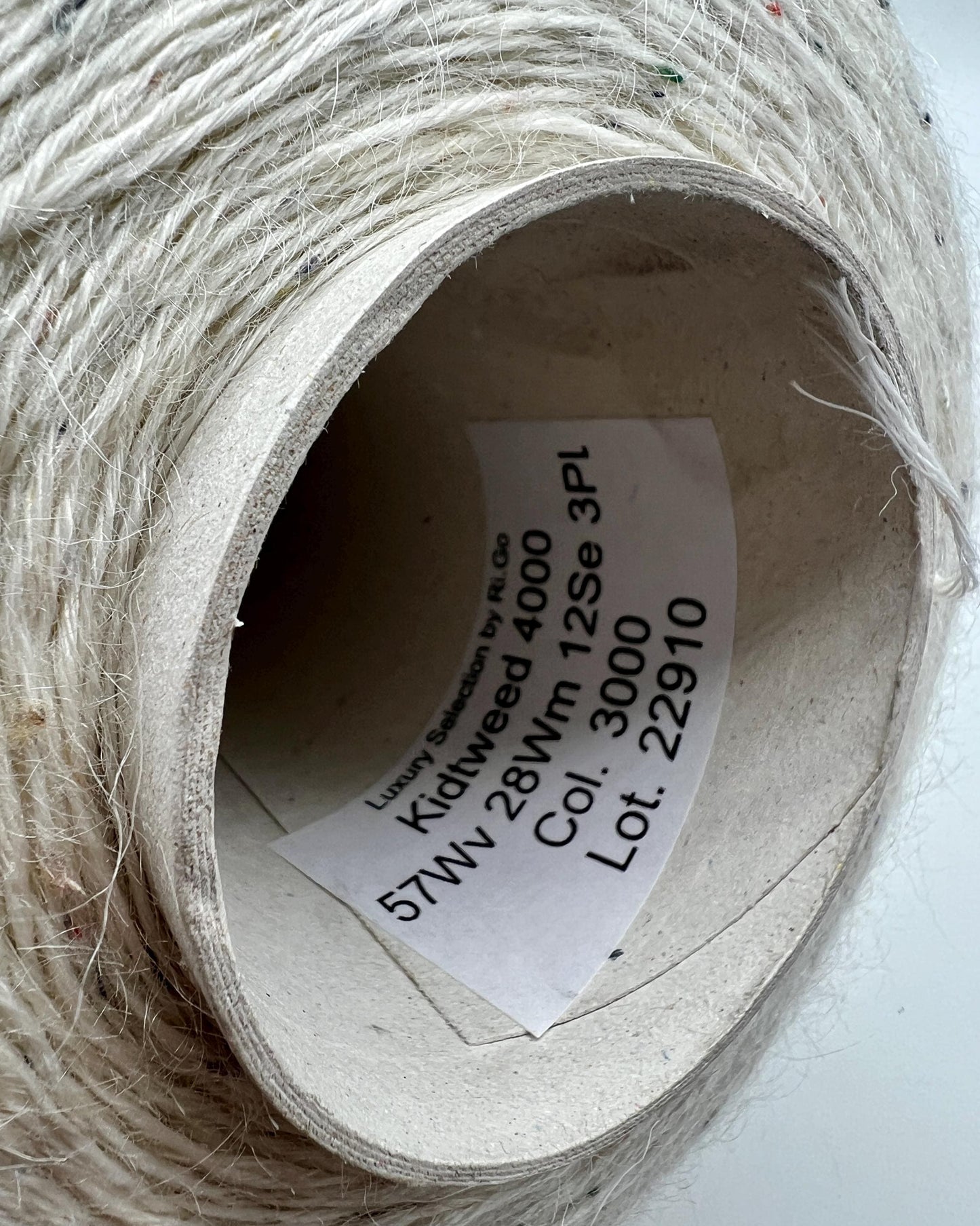 Spool of white thread with a label inside on a white background