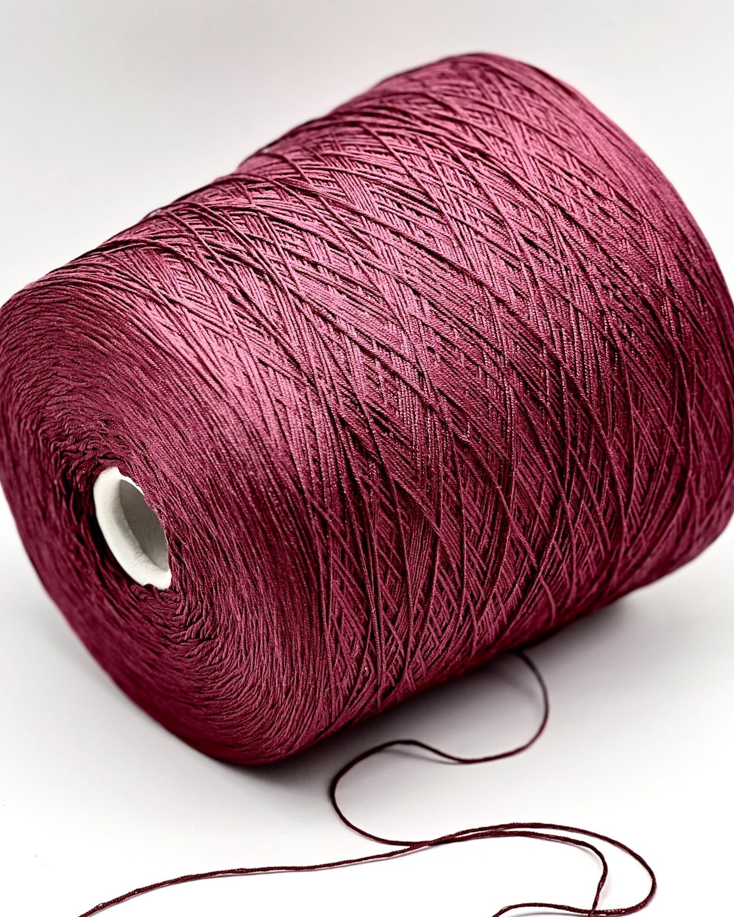 Spool of red yarn on a white background