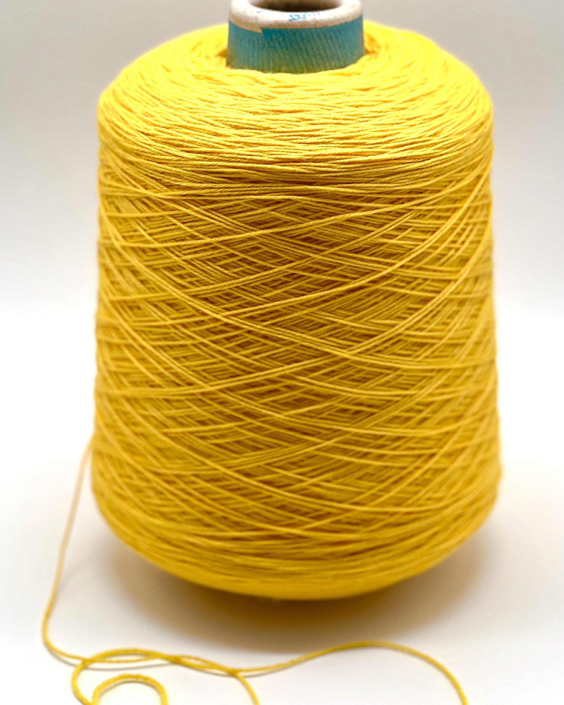 Spool of yellow yarn on a white background
