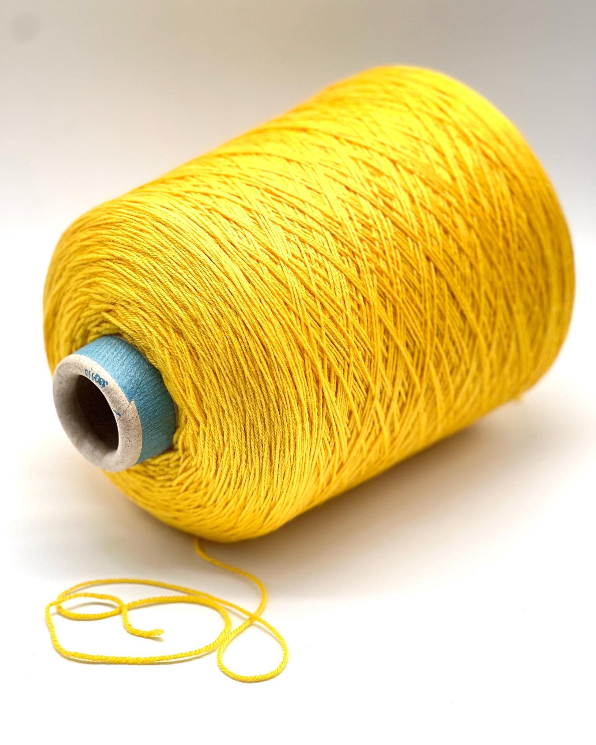 Yellow spool of thread on a white background