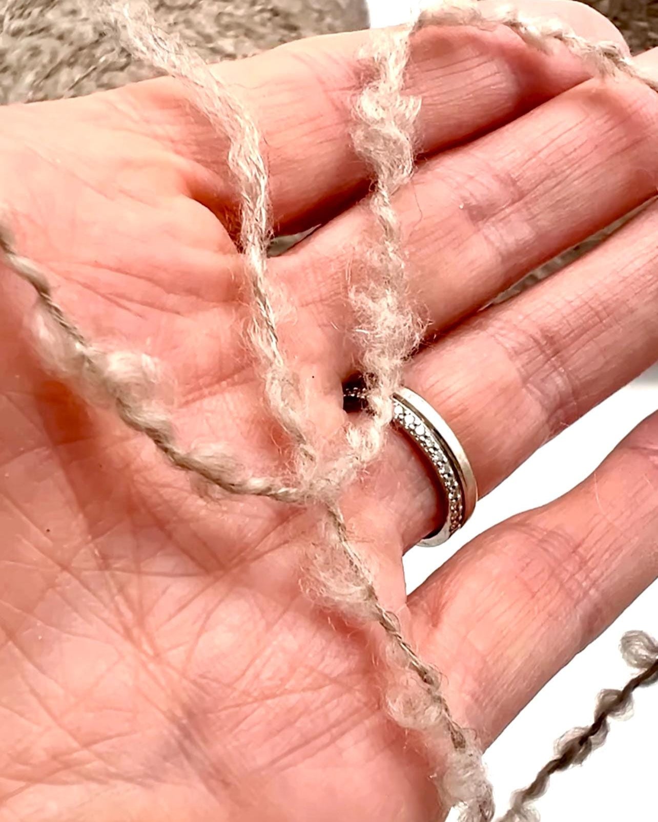 Hand holding a piece of string with a blurred background
