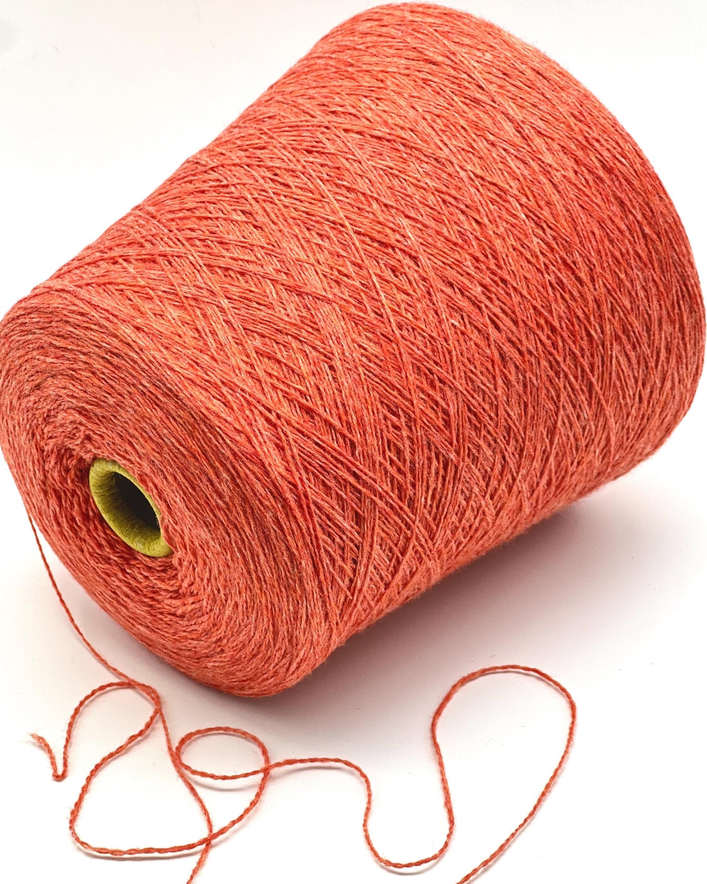 Spool of orange yarn on a white background