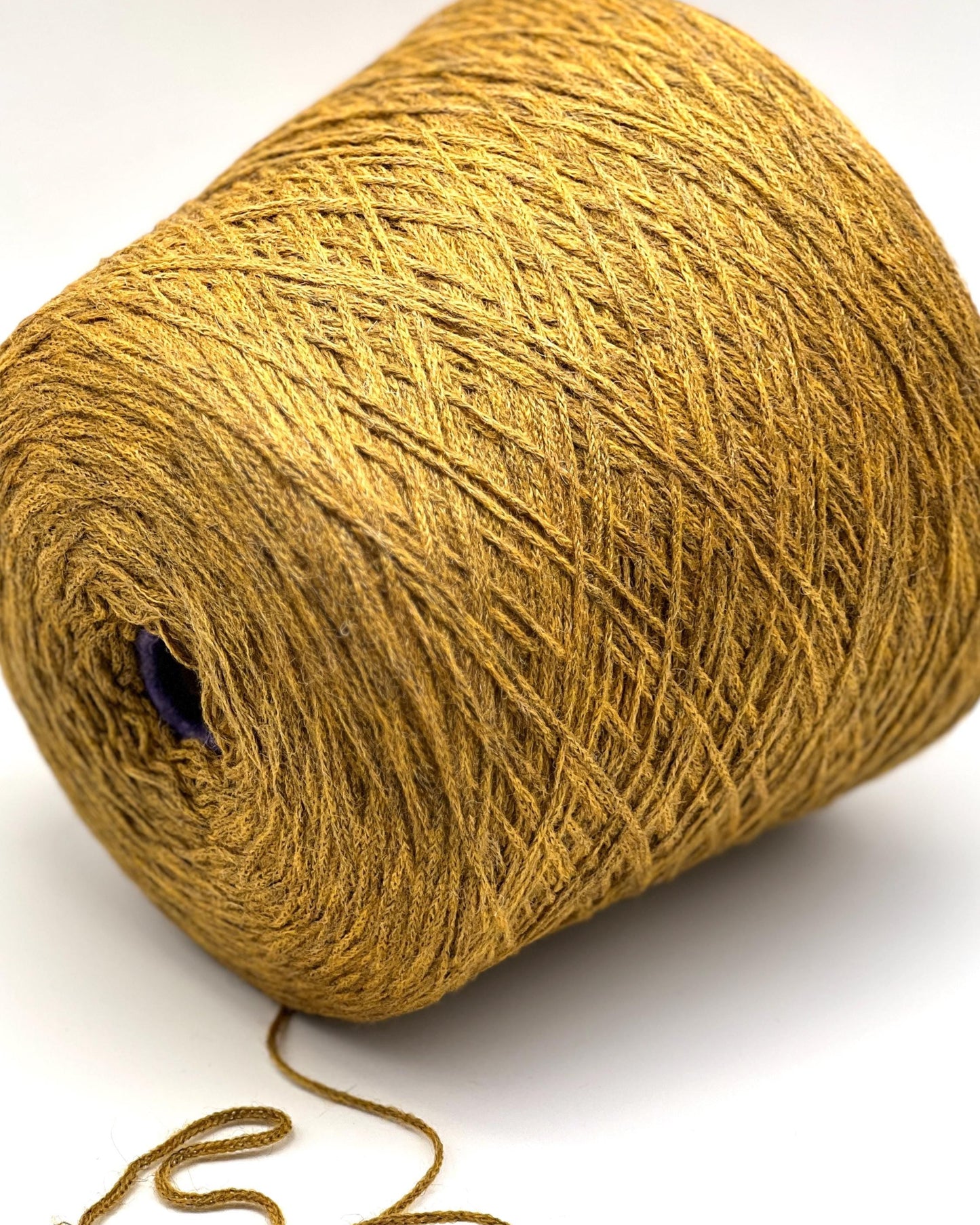 Large ball of gold yarn on a white background