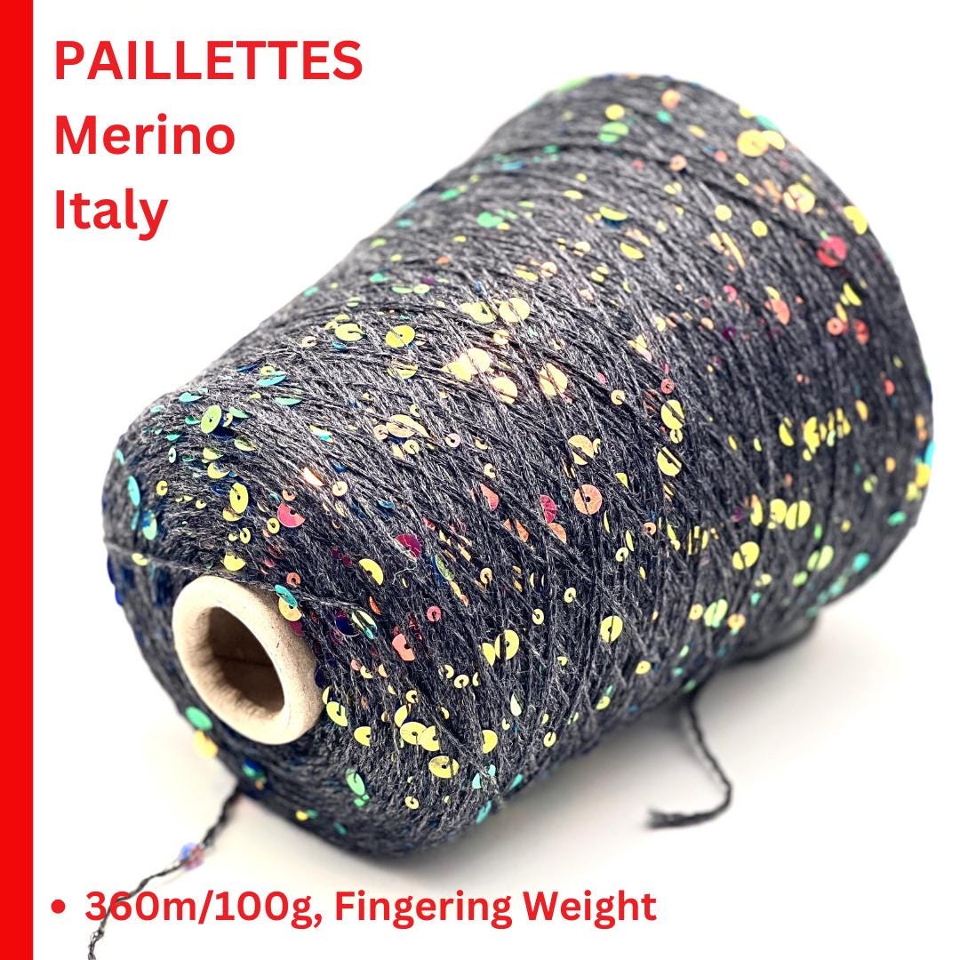 Spool of yarn with colorful paillettes on a white background, labeled 'Paillettes Merino Italy'.