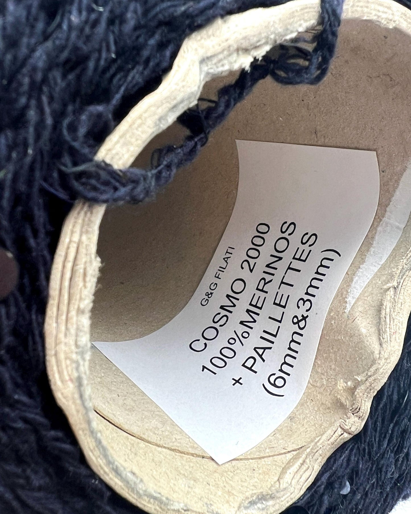 Close-up of yarn with a label on a dark textured background