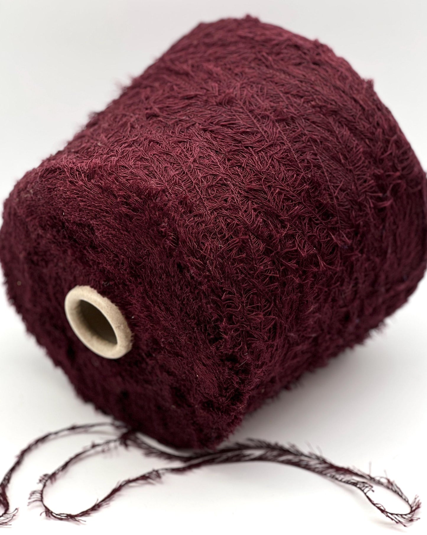 Ball of dark red yarn on a white background
