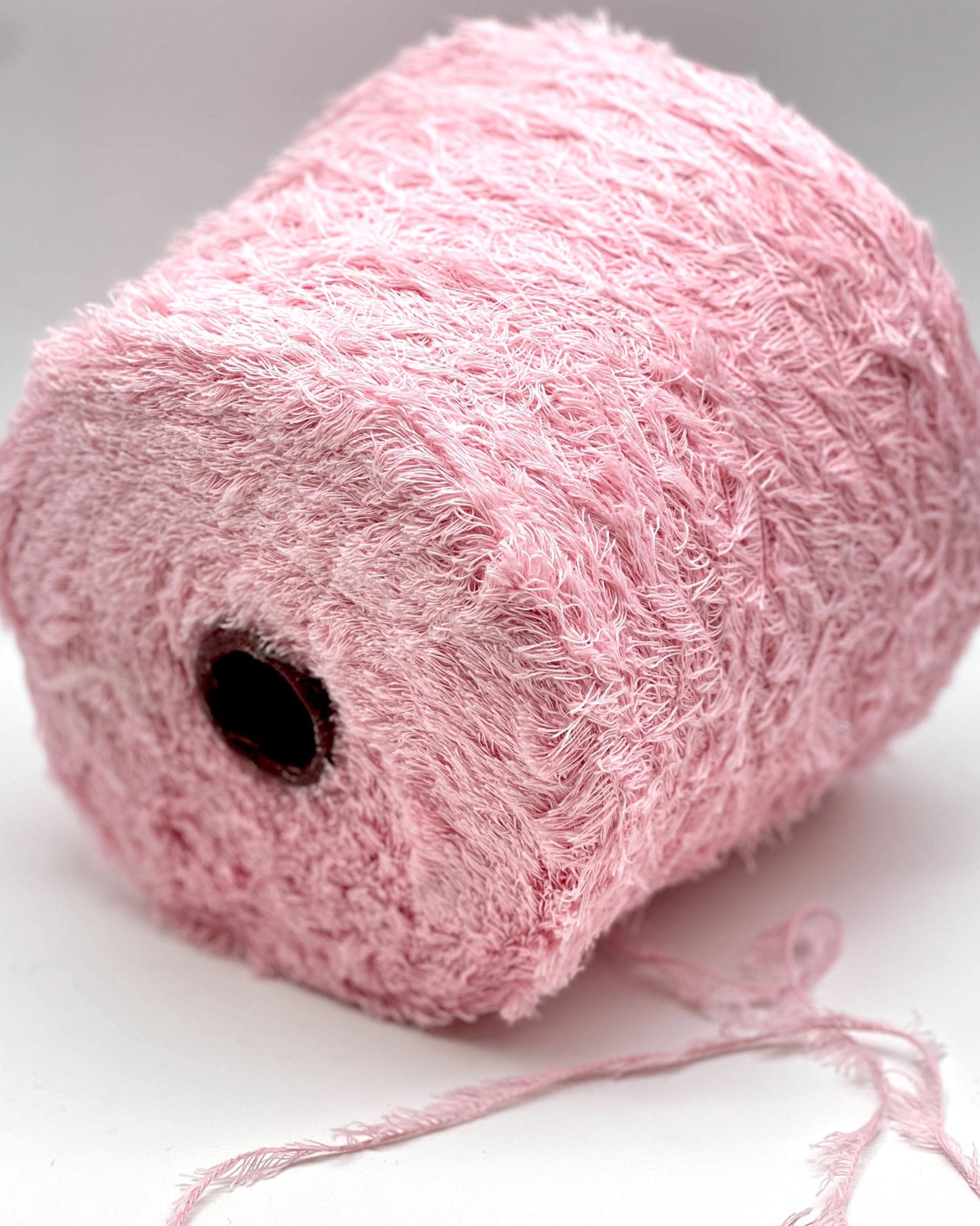 Close-up of a pink skein of yarn on a white background
