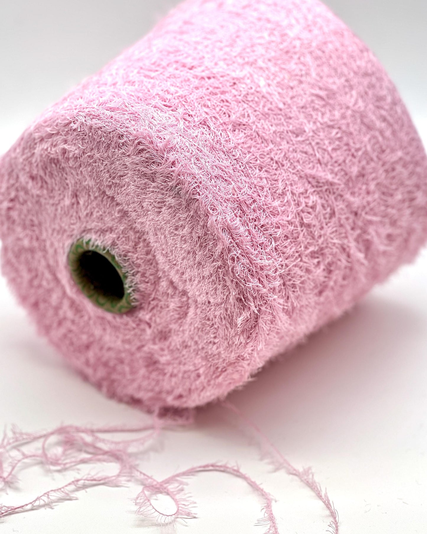 Pink yarn roll on a white background