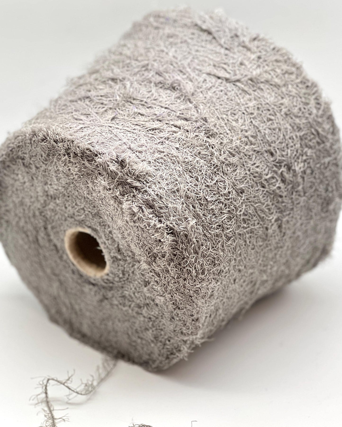 Roll of gray yarn on a white background