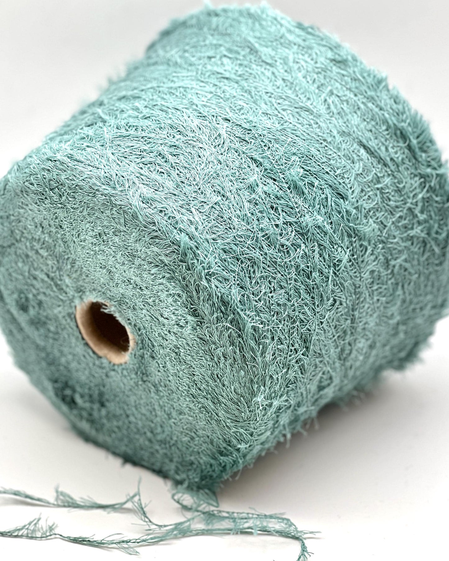 Roll of teal string on a white background