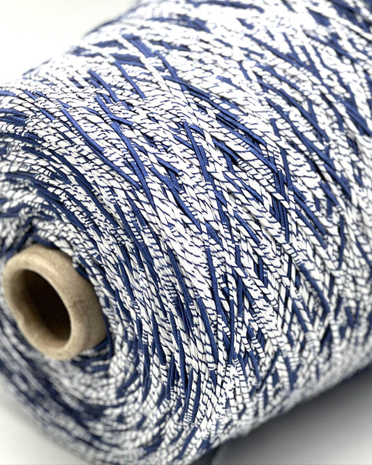 Close-up of a spool of blue and white yarn on a light background