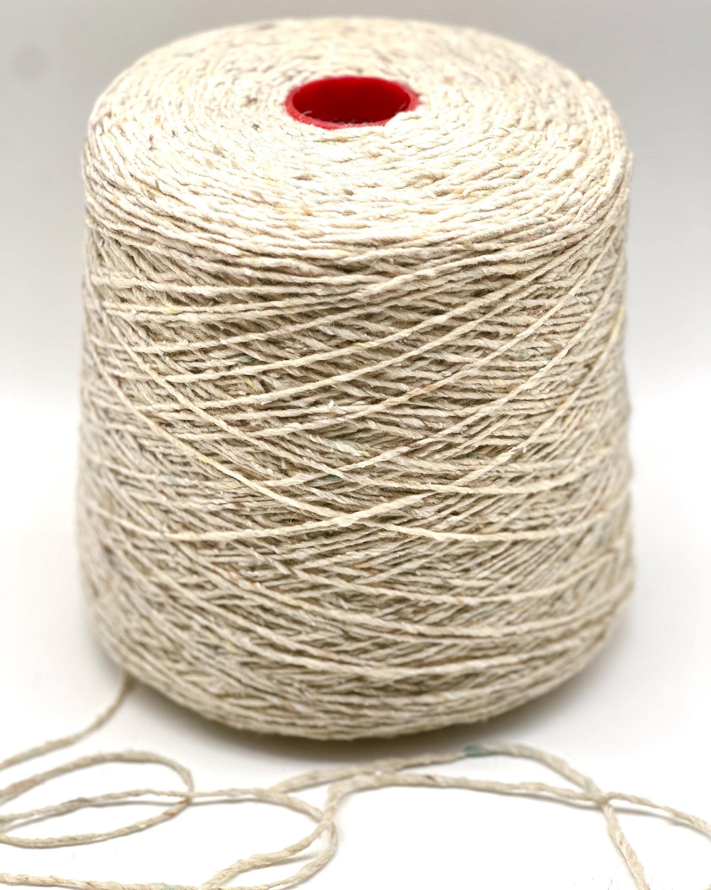 Spool of beige thread on a white background