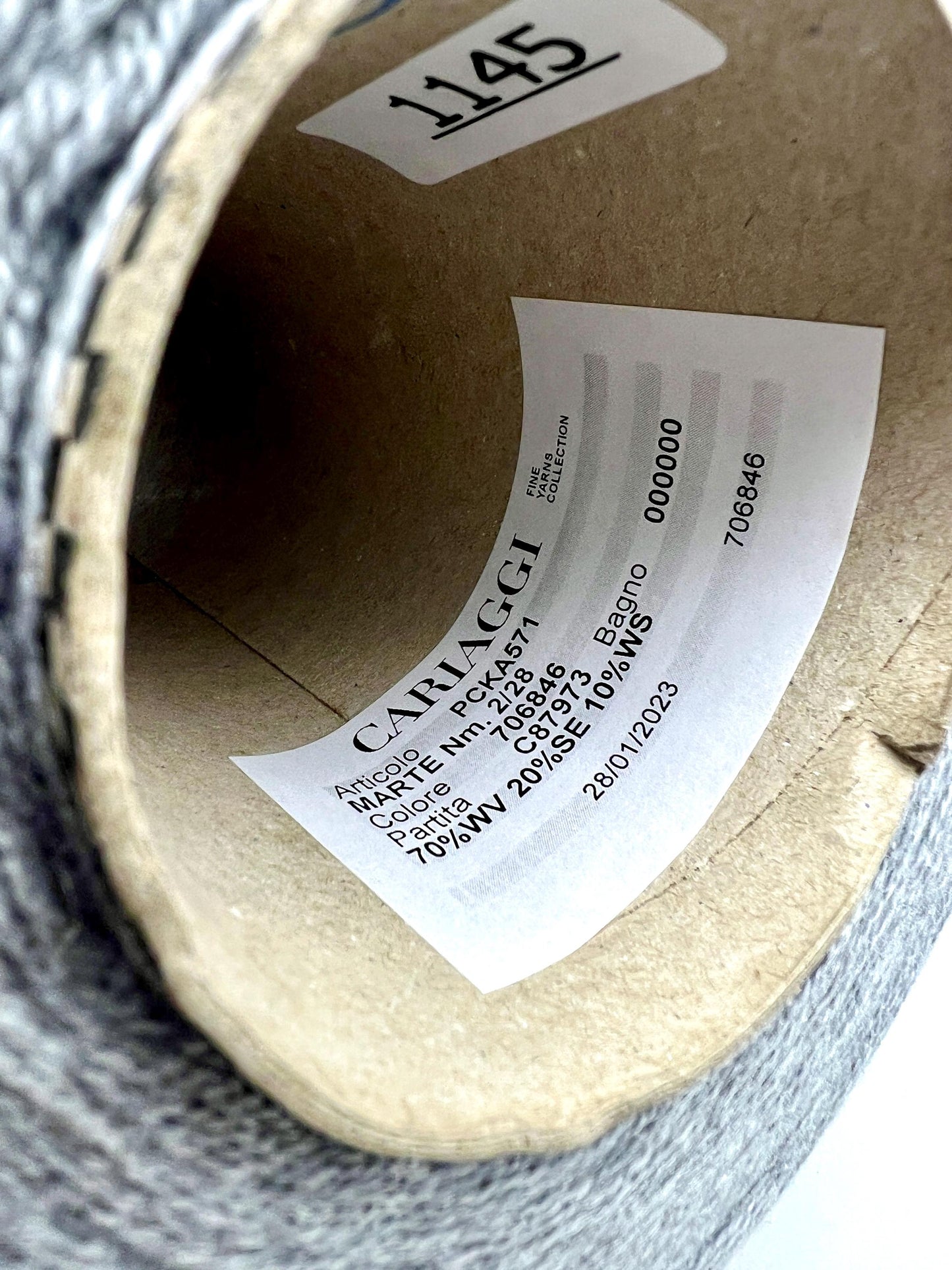 Close-up of a roll of fabric with a label on a cardboard tube