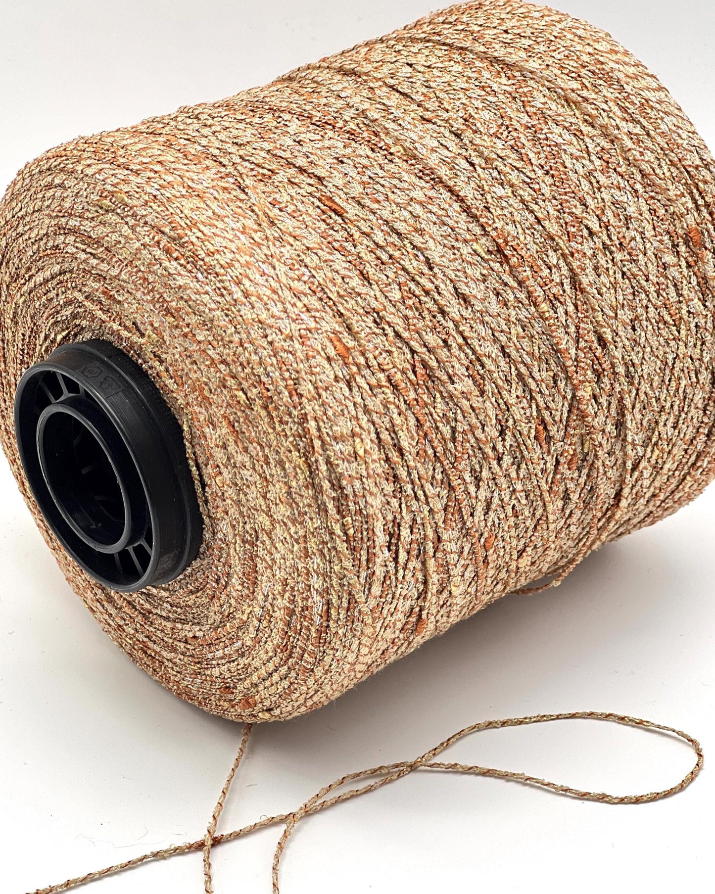 Spool of beige thread on a white background