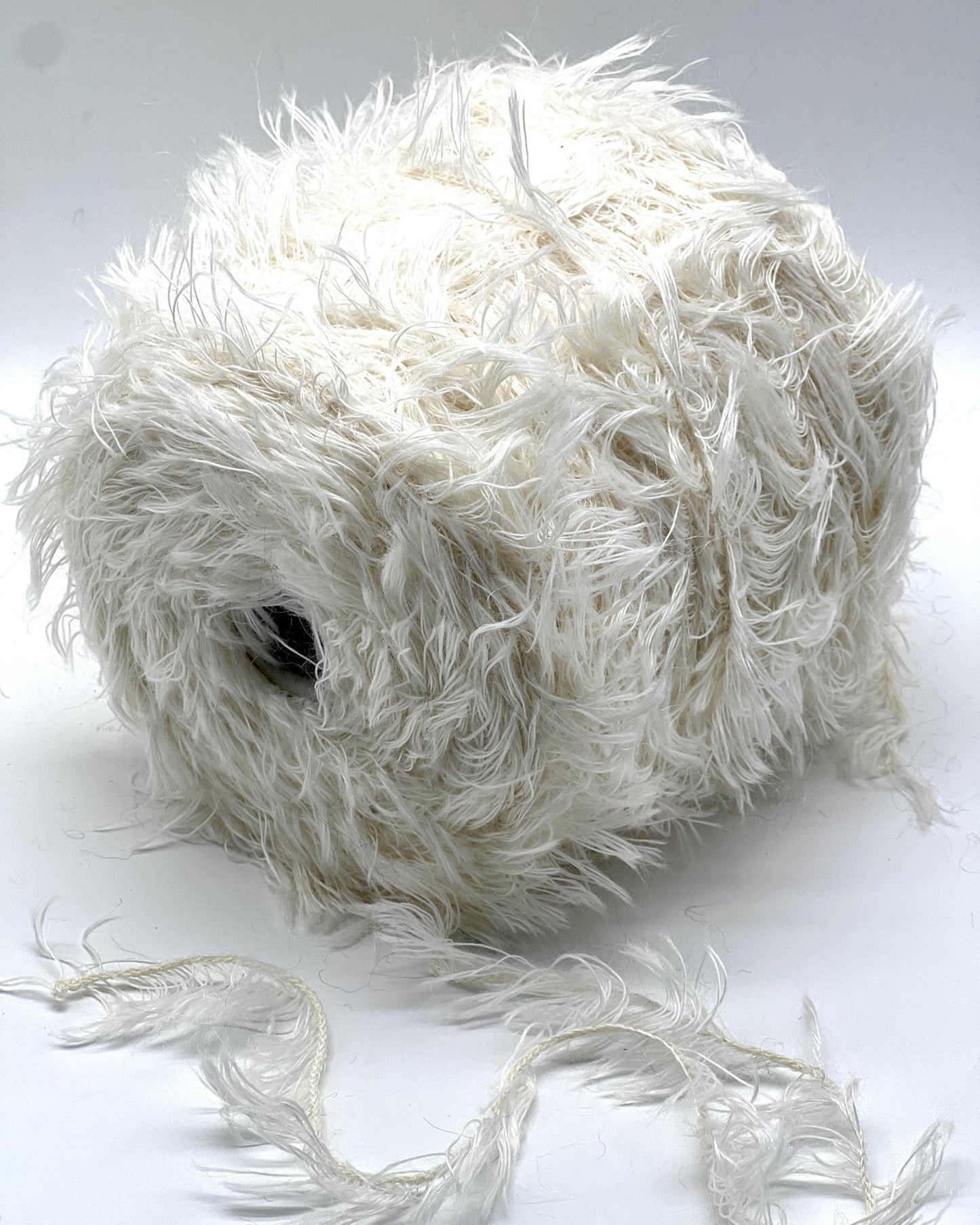 Ball of white yarn on a white background
