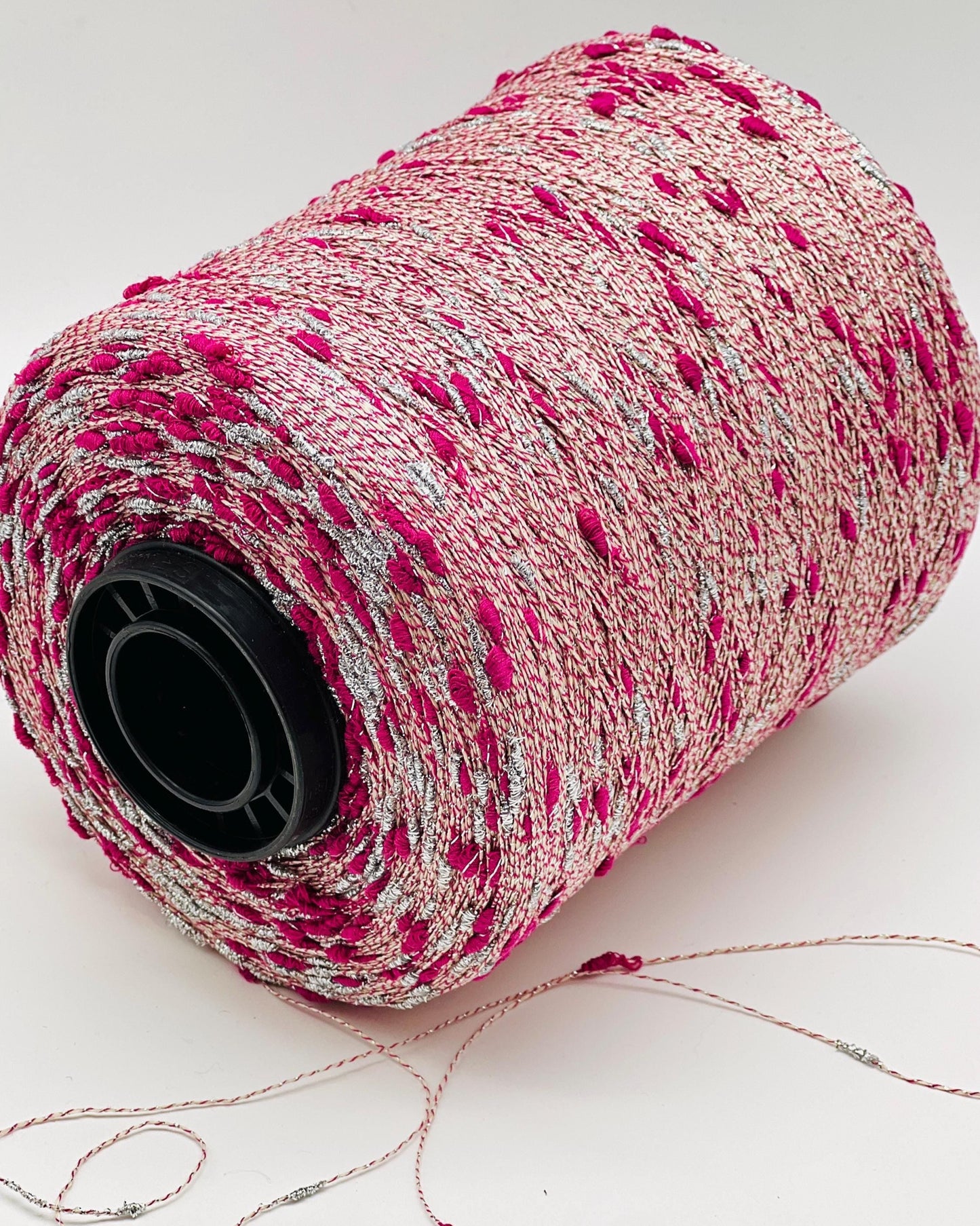 Spool of pink and gray thread on a white background
