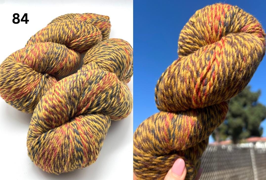 Multicolored skein of yarn on a white background with a blue sky and trees in the background.