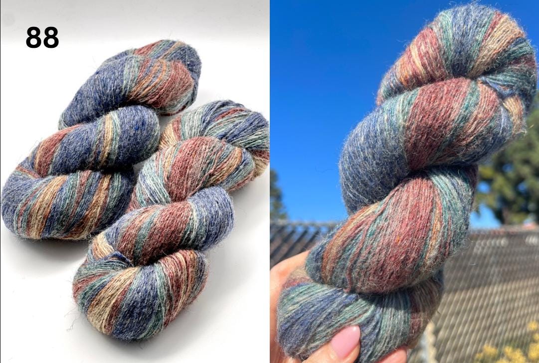 Multicolored skein of yarn on a white background and held in hand with outdoor background.