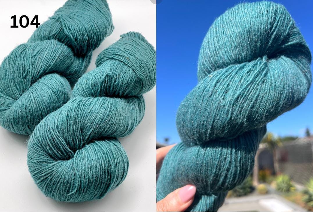Teal skein of yarn with a blurred outdoor background