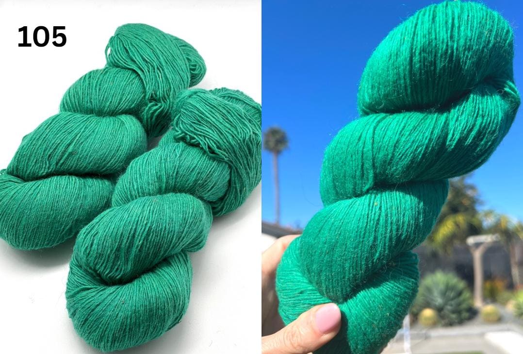 Green yarn skeins on a white background and held in a hand with a blurred outdoor background.
