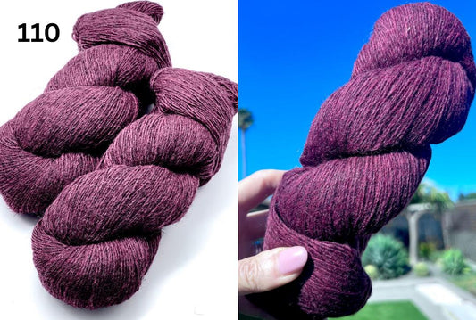 Purple yarn skeins with a blurred outdoor background