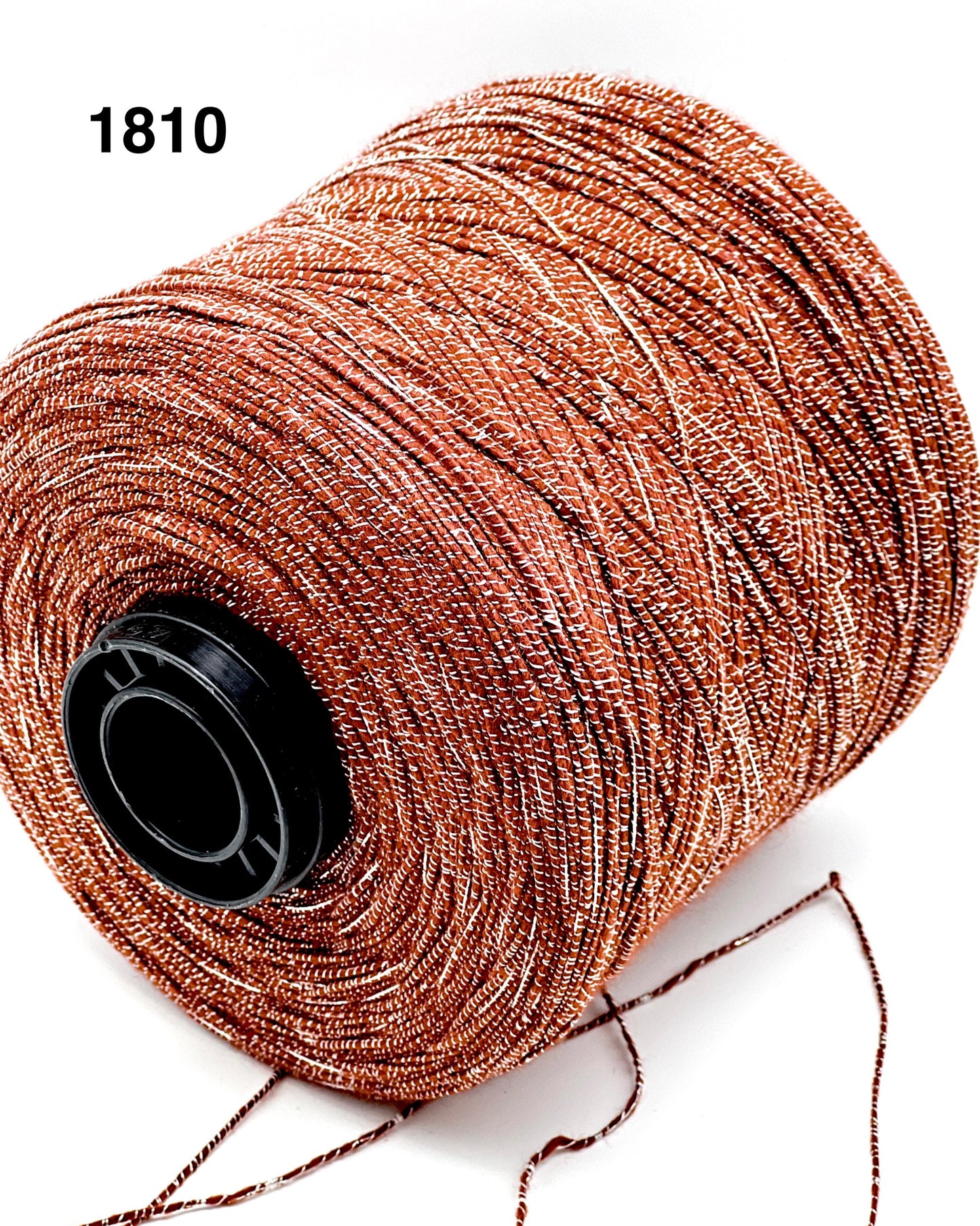 Spool of brown thread with a black spool cap on a white background