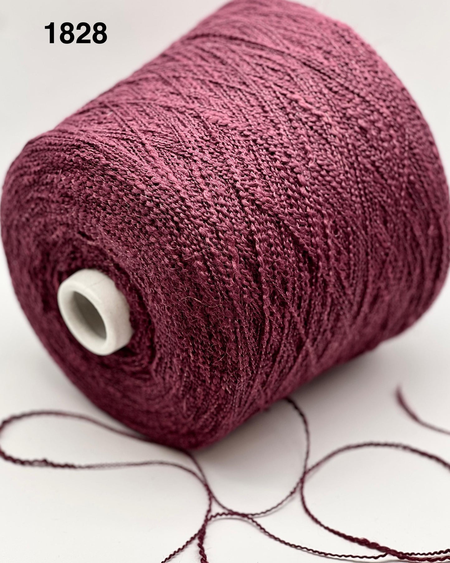 Spool of purple yarn on a white background
