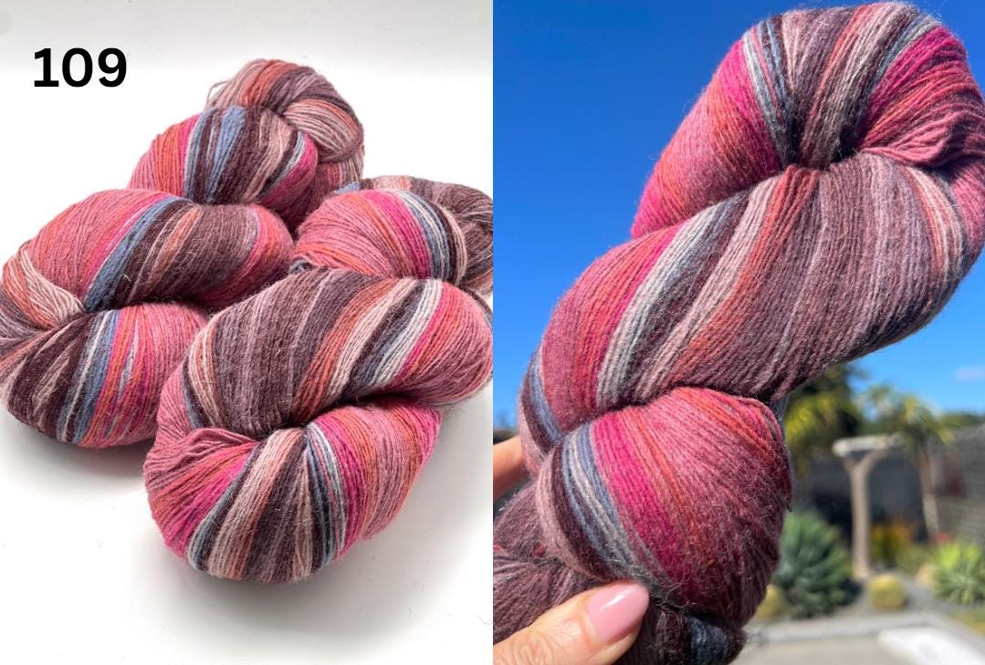 Multicolored skein of yarn on a white background with a blurred outdoor scene.