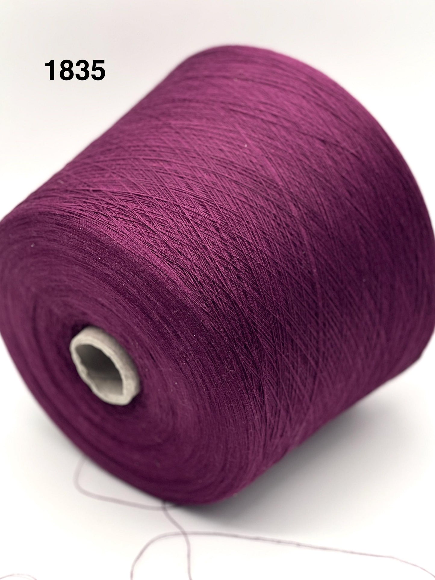Purple spool of yarn on a white background
