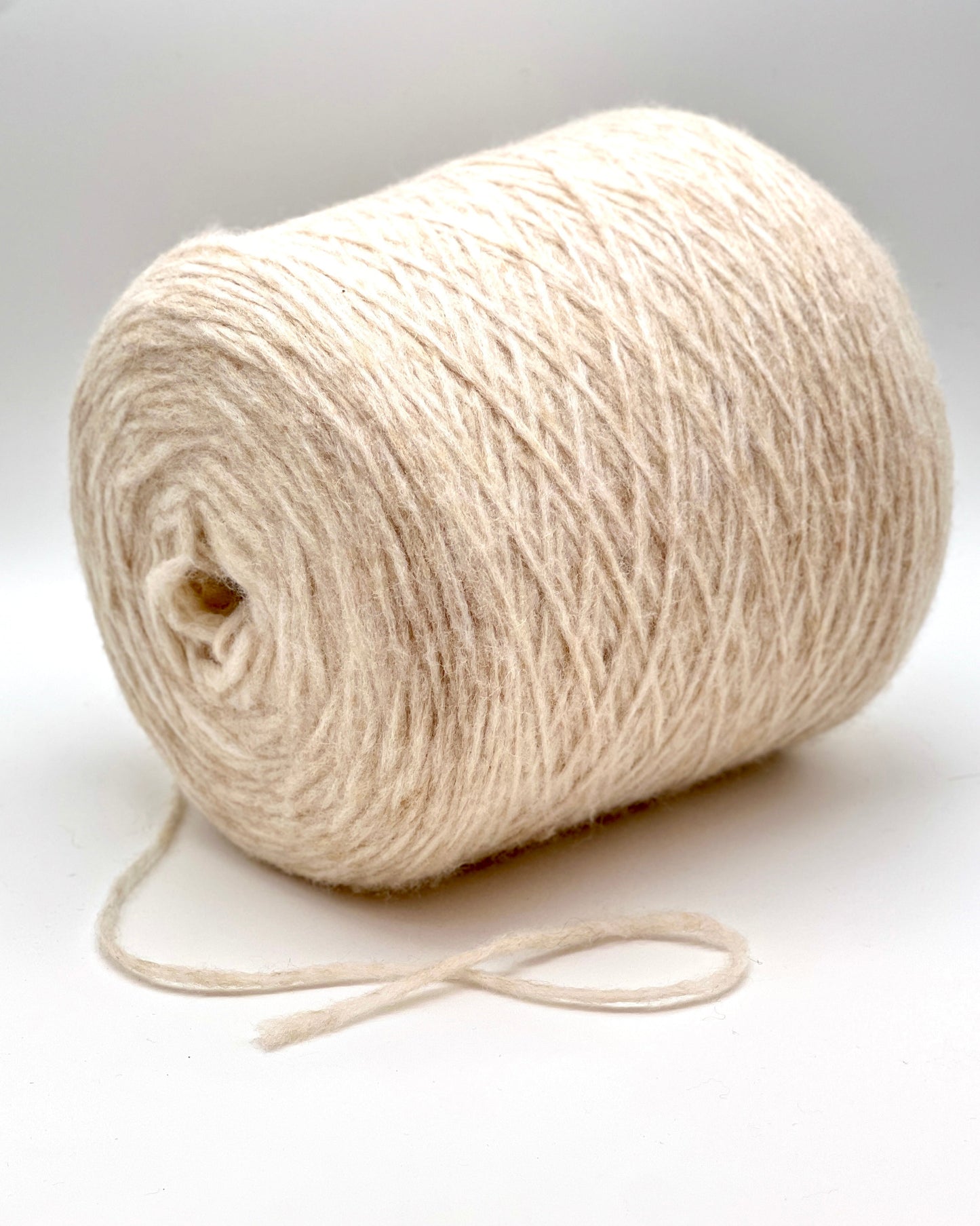 Roll of beige yarn on a white background