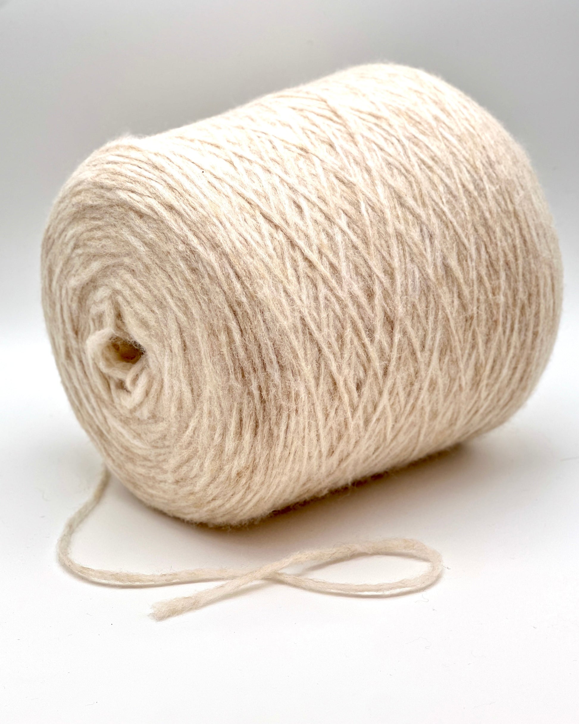 Roll of beige yarn on a white background