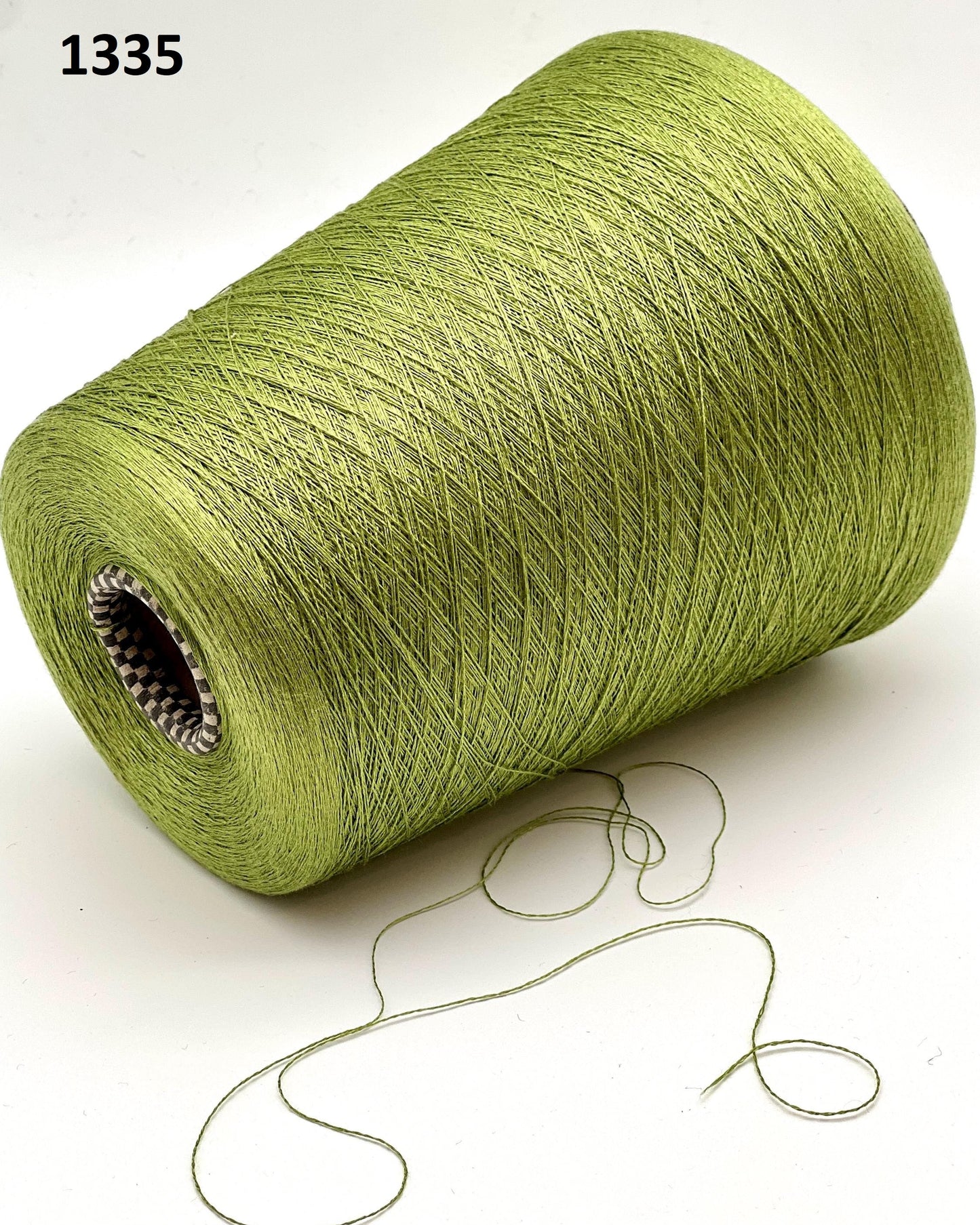 Green spool of yarn on a white background