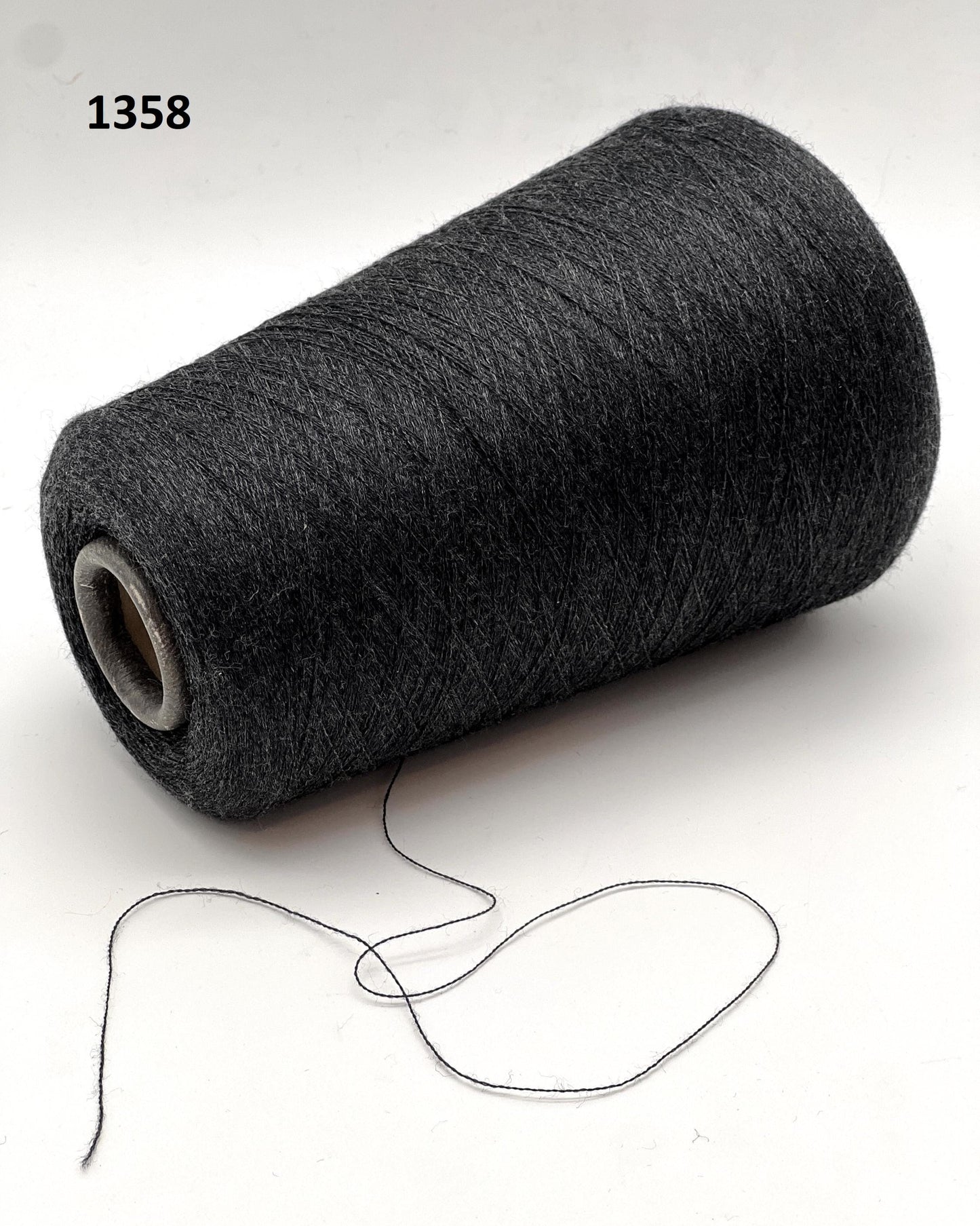 Roll of dark gray yarn on a white background