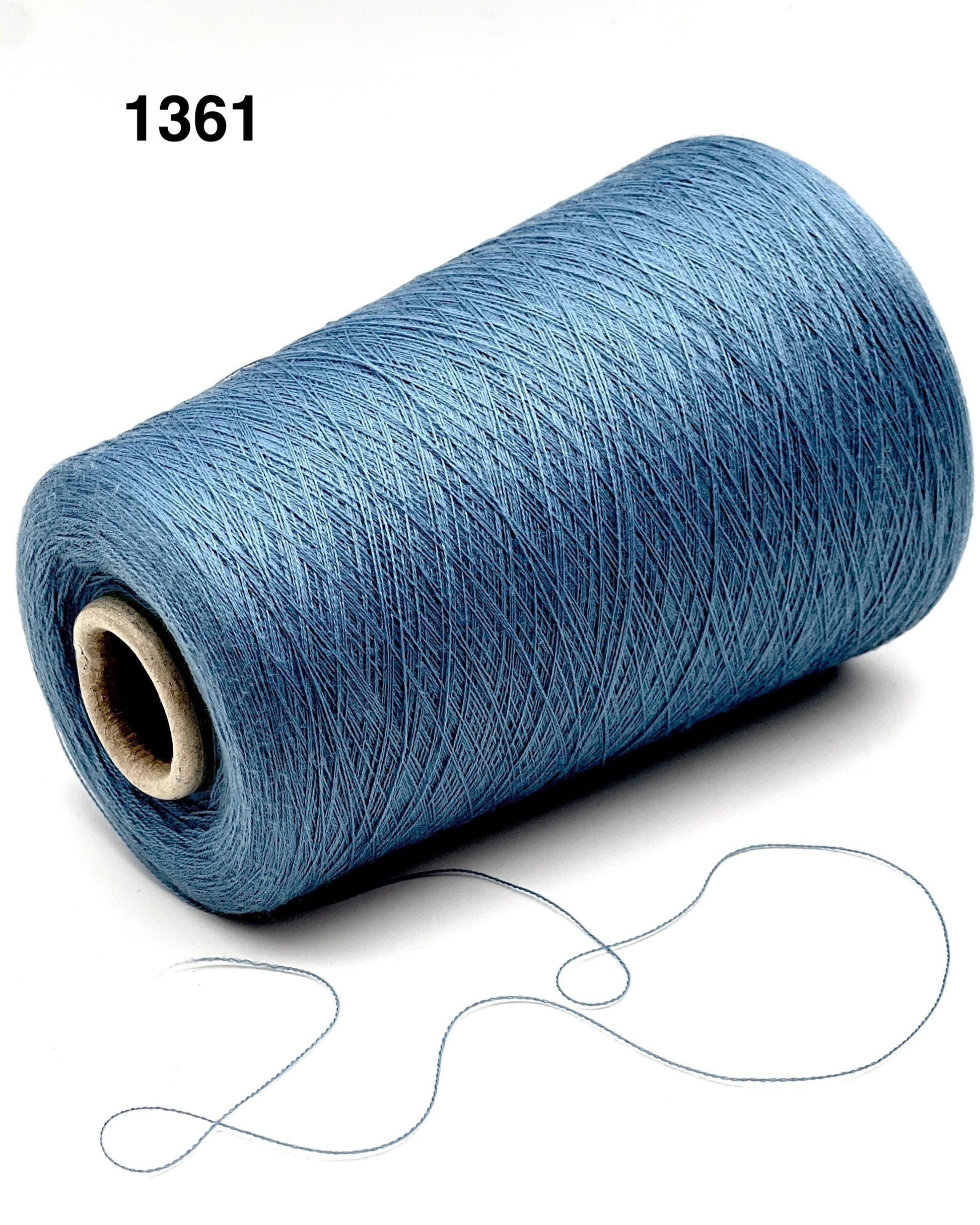 Blue spool of thread with a small piece of thread on a white background