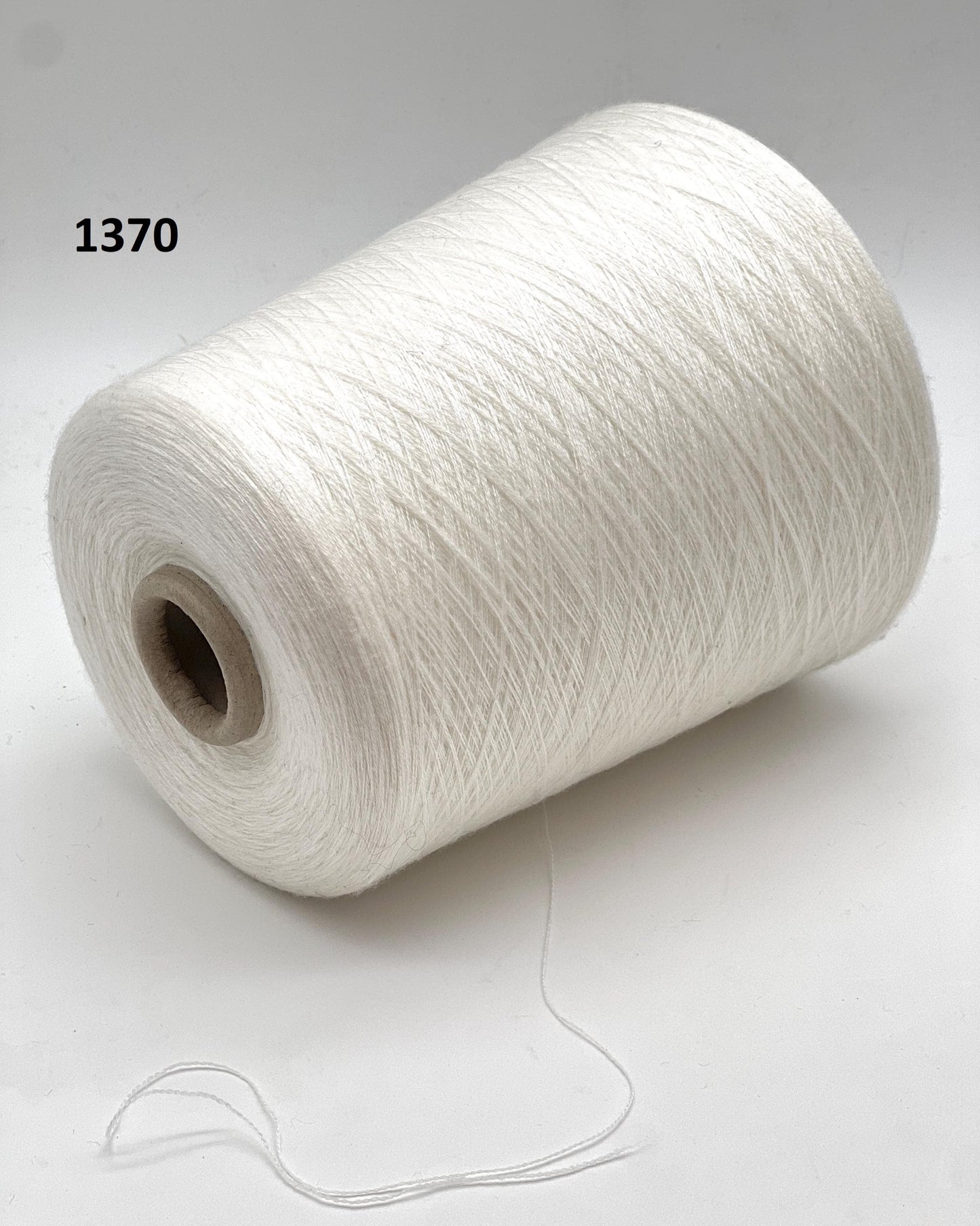 Spool of white yarn on a light gray background