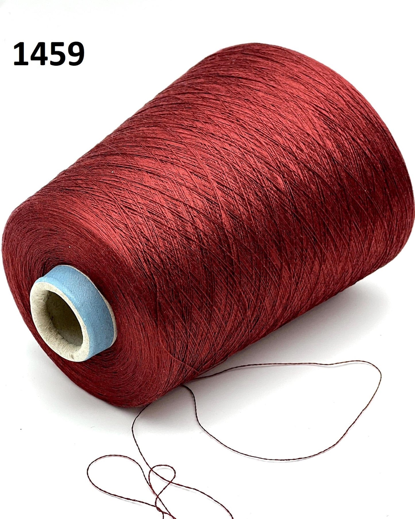 Red spool of thread with a small amount of thread hanging out on a white background