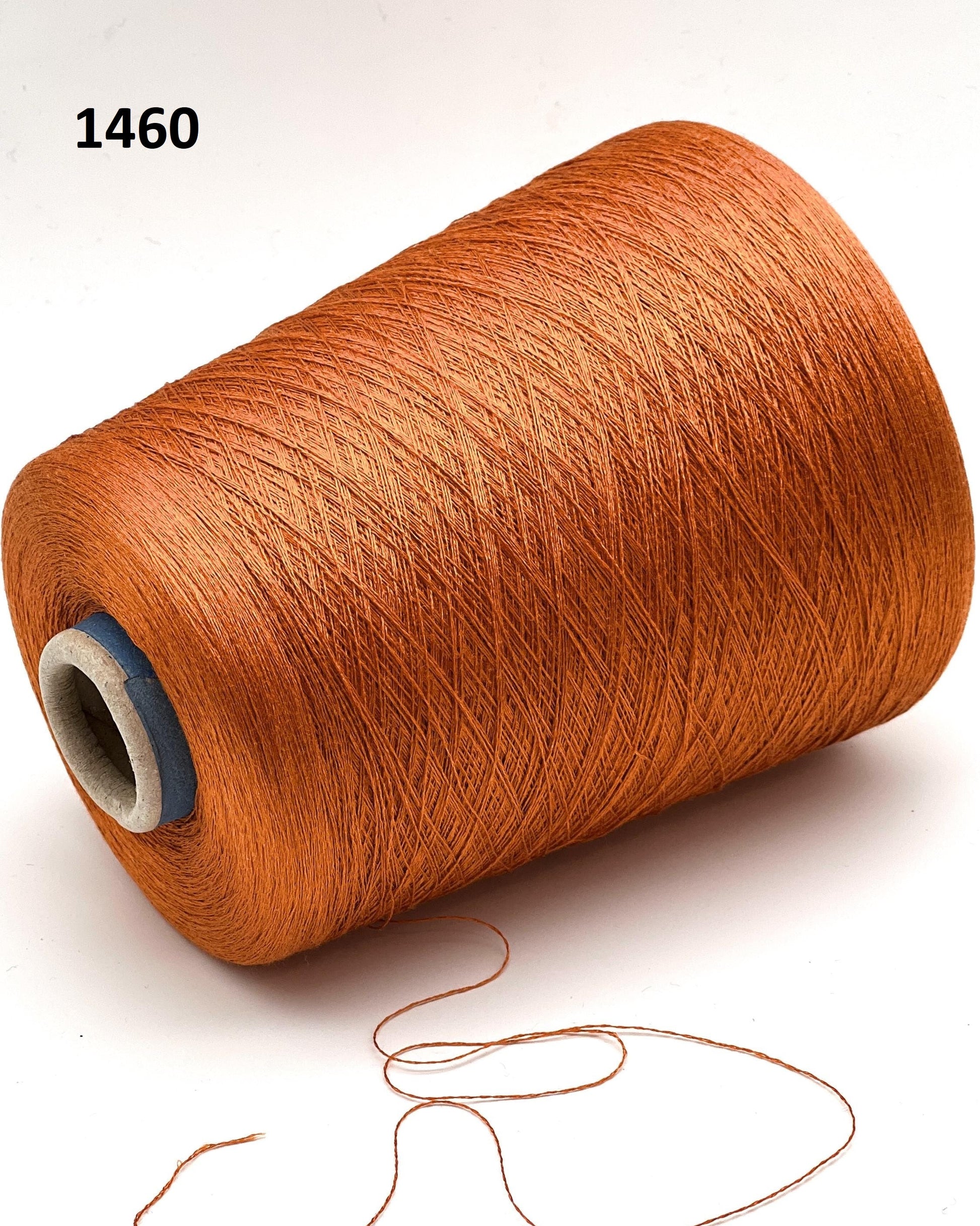 Brown spool of thread with a small amount of thread hanging out on a white background