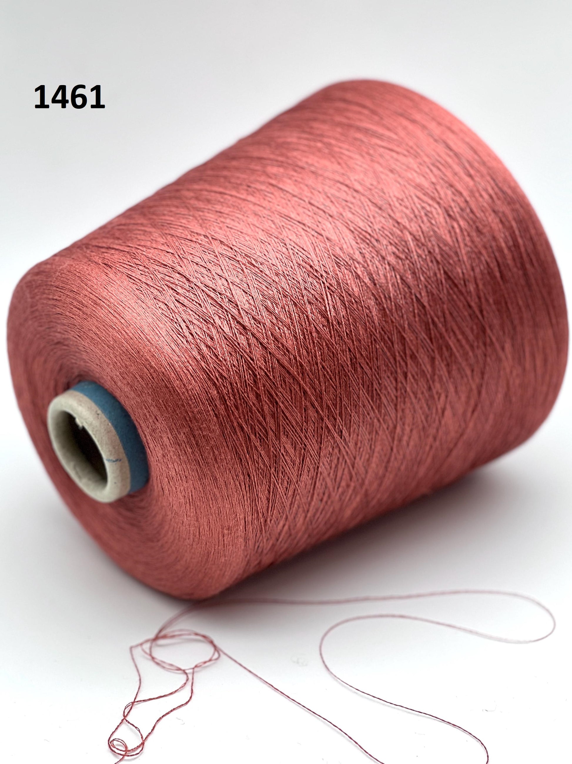 Spool of red thread on a white background with a small drawing of a dress.