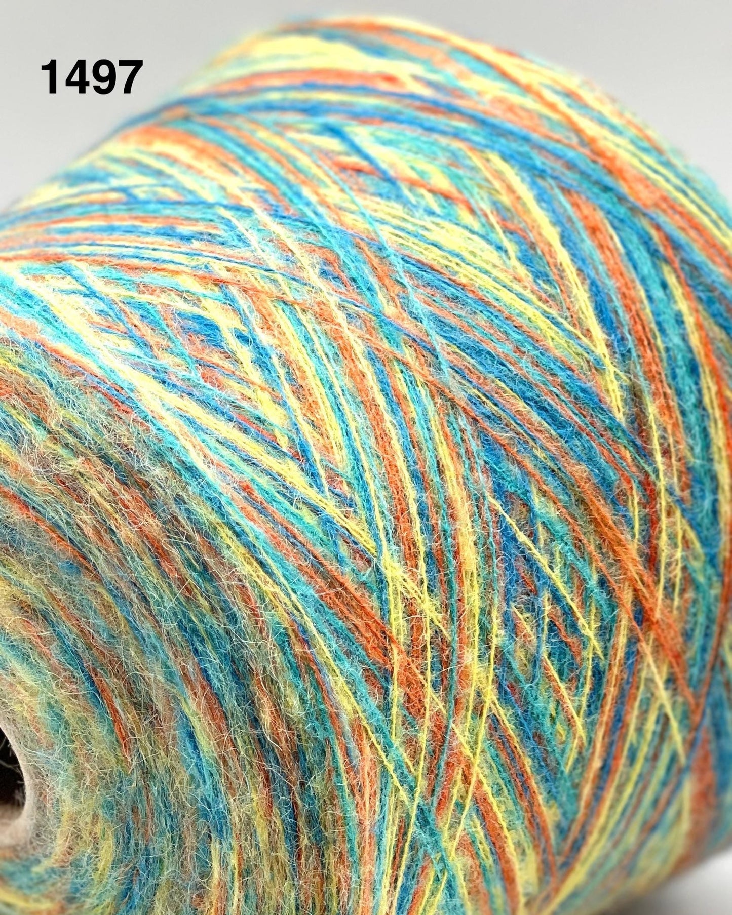 Multicolored yarn spool with a gradient of blue, orange, and yellow on a light background.