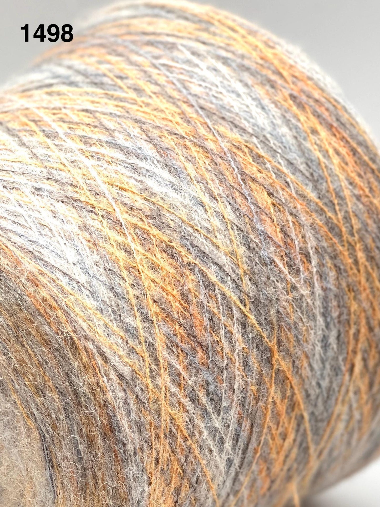 Close-up of a ball of yarn with orange and gray fibers.